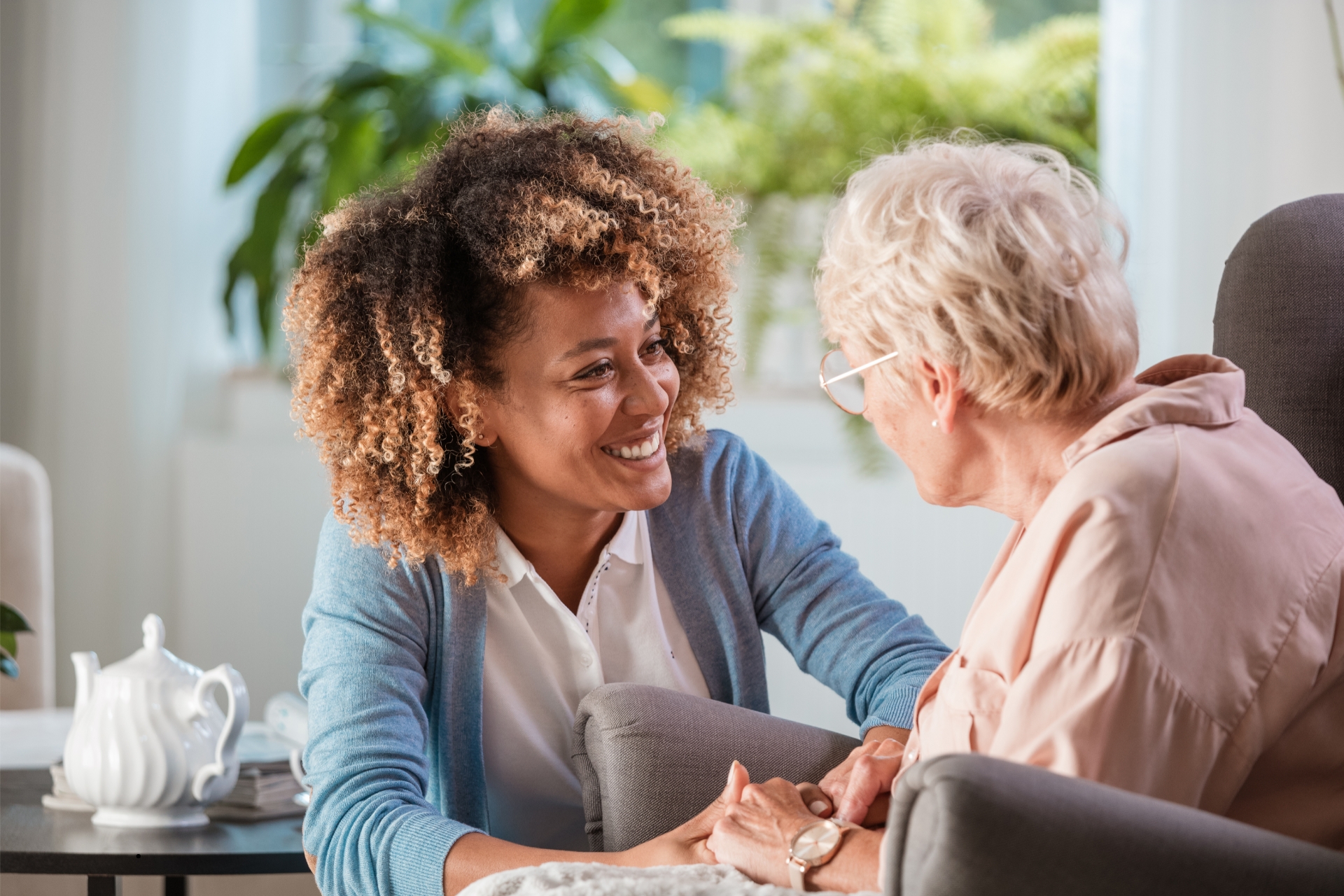 Two women talking together in a bright living room.